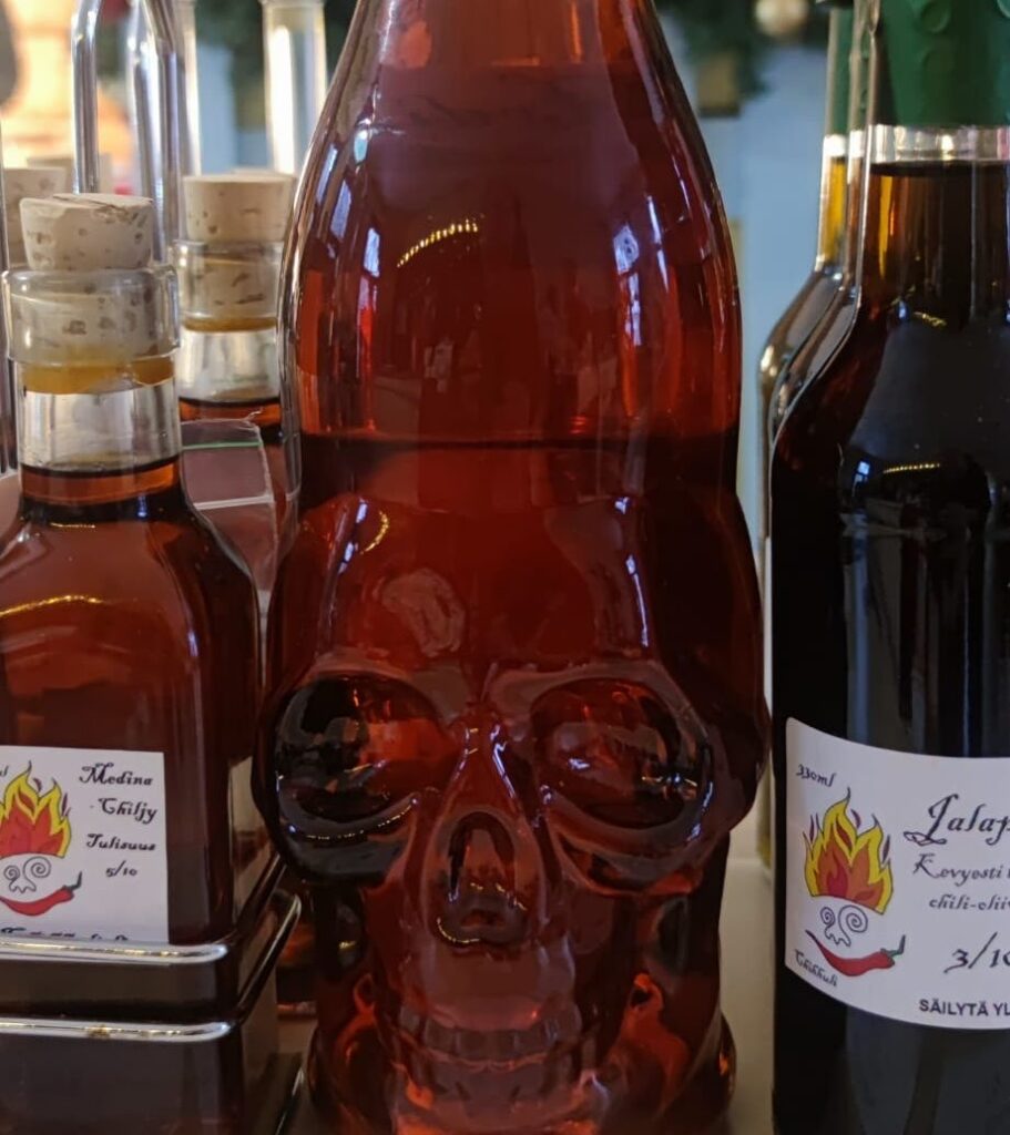 Käsityönä valmistettuja vegaanisia chiliöljyjä pulloissa.